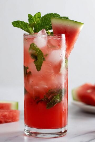Watermelon Mojito in a glass with mint, ice, and a watermelon slice garnish.